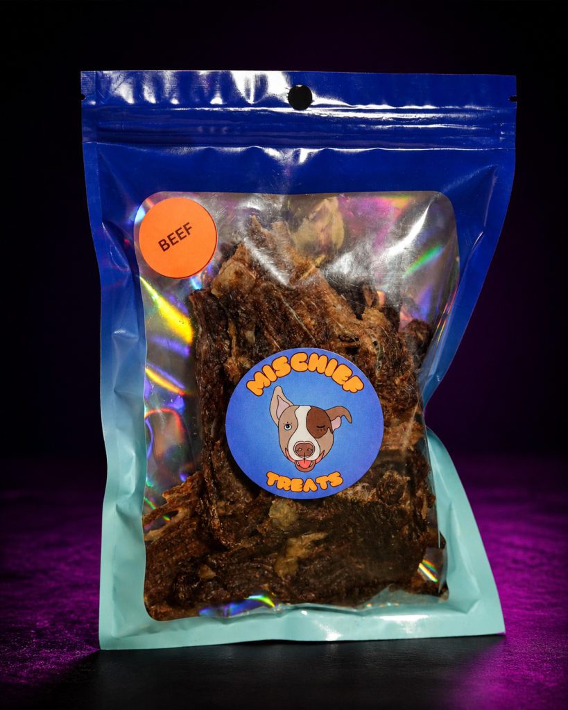 Mischief Treats Beef dog-treat pouch against a dark studio background