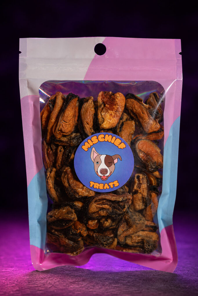 Mischief Treats Mussels dog-treat pouch against a dark studio background